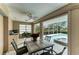 Covered outdoor dining area with stylish furniture, ceiling fan, and a view of the sparkling pool and waterway at 414 Caicos Dr, Punta Gorda, FL 33950
