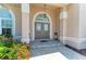 Elegant front entry with decorative doors, tiled steps, and manicured landscaping at 414 Caicos Dr, Punta Gorda, FL 33950