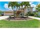 Beautiful home with a circular driveway, well-manicured lawn, and lush tropical landscaping at 414 Caicos Dr, Punta Gorda, FL 33950