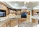 Chef's kitchen featuring granite countertops, wooden cabinets, and modern appliances at 414 Caicos Dr, Punta Gorda, FL 33950