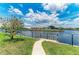 Beautiful waterfront view with mature tree, lush lawn, and a private dock for relaxing by the canal at 414 Caicos Dr, Punta Gorda, FL 33950