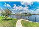 Beautiful waterfront view with mature tree, lush lawn, and a private dock for relaxing by the canal at 414 Caicos Dr, Punta Gorda, FL 33950