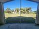 Screened porch view capturing the open green space and palm trees at 4390 Wischamper St, Port Charlotte, FL 33948