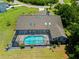 Aerial view of home with an in-ground pool within a screened enclosure, lush backyard, and mature trees at 501 Fairmont Ter, Port Charlotte, FL 33954