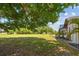An expansive backyard with a screened-in pool, mature trees and views of surrounding landscaping at 501 Fairmont Ter, Port Charlotte, FL 33954