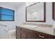 Bathroom features a dark wood vanity, granite countertop, framed mirror, and window at 501 Fairmont Ter, Port Charlotte, FL 33954