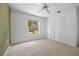 Bedroom with carpet flooring, fan and large window with view of the yard at 501 Fairmont Ter, Port Charlotte, FL 33954