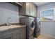Well-lit laundry room with washer, dryer, sink and cabinets at 501 Fairmont Ter, Port Charlotte, FL 33954