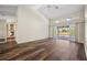 Open-plan living room with wood floors, vaulted ceiling, and sliding doors to pool area at 501 Fairmont Ter, Port Charlotte, FL 33954