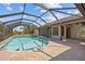 Screened-in pool with stone patio and views of backyard at 501 Fairmont Ter, Port Charlotte, FL 33954