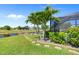 Lush backyard with canal access, private dock, and a screened-in pool offers a tranquil outdoor lifestyle with serene waterfront views at 69 Bunker Rd, Rotonda West, FL 33947