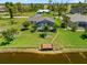 Charming backyard with a screened-in pool, waterfront access, a private dock, and lush landscaping, ideal for outdoor living at 69 Bunker Rd, Rotonda West, FL 33947