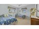 Cheerful bedroom with twin beds, floral accents, and ceiling fan at 69 Bunker Rd, Rotonda West, FL 33947
