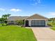 Charming single-story home with a well-manicured lawn, a two-car garage, and tasteful landscaping at 69 Bunker Rd, Rotonda West, FL 33947