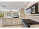 Bright kitchen with modern appliances, white cabinets, and a view into the living area at 69 Bunker Rd, Rotonda West, FL 33947
