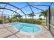 Inviting screened-in pool area with a tranquil spa and beautiful tropical landscaping at 69 Bunker Rd, Rotonda West, FL 33947