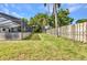 Spacious backyard featuring lush lawn and partial view of the home's screened-in pool area at 6916 Rex Ln, Sarasota, FL 34243