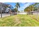 Backyard view with a well-maintained lawn and partial view of the screened-in pool at 6916 Rex Ln, Sarasota, FL 34243