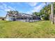 Expansive backyard showcasing the home's screened-in pool, lawn, and exterior at 6916 Rex Ln, Sarasota, FL 34243