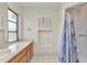 Neutral bathroom featuring a vanity with a window and a shower with a blue and white curtain at 6916 Rex Ln, Sarasota, FL 34243