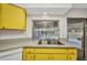 View of the kitchen sink, window, and yellow cabinets overlooking the pool outside at 6916 Rex Ln, Sarasota, FL 34243