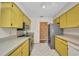 Kitchen featuring stainless steel appliances and yellow cabinets at 6916 Rex Ln, Sarasota, FL 34243
