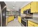 Bright kitchen with yellow cabinetry, stainless steel appliances, and tile flooring at 6916 Rex Ln, Sarasota, FL 34243
