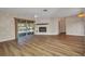 Spacious living room with a fireplace, new floors, and sliding glass doors to the pool at 6916 Rex Ln, Sarasota, FL 34243