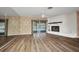 Spacious living room with a fireplace, new floors, and sliding glass doors to the pool at 6916 Rex Ln, Sarasota, FL 34243