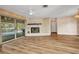 Spacious living room with a fireplace, new floors, and sliding glass doors to the pool at 6916 Rex Ln, Sarasota, FL 34243
