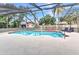 Backyard swimming pool within a screened enclosure surrounded by mature trees at 6916 Rex Ln, Sarasota, FL 34243