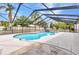 Backyard swimming pool within a screened enclosure surrounded by mature trees at 6916 Rex Ln, Sarasota, FL 34243