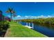 Waterfront backyard with a private dock surrounded by lush trees and tropical landscaping at 695 Macedonia Dr, Punta Gorda, FL 33950