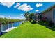 Lovely backyard with lush grass, dock, water access, and a screened-in lanai, perfect for outdoor entertaining at 695 Macedonia Dr, Punta Gorda, FL 33950