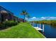 Waterfront backyard with a private dock surrounded by lush trees and tropical landscaping at 695 Macedonia Dr, Punta Gorda, FL 33950