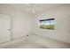 Well-lit bedroom with a ceiling fan, carpet, and a large window offering serene backyard views at 695 Macedonia Dr, Punta Gorda, FL 33950