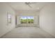 Bedroom features carpet and two windows with plantation shutters and water views at 695 Macedonia Dr, Punta Gorda, FL 33950