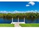 Private dock overlooking peaceful water surrounded by lush green trees and clear skies at 695 Macedonia Dr, Punta Gorda, FL 33950