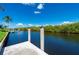 Canal view from dock, featuring tranquil water, tropical vegetation, and a clear blue sky at 695 Macedonia Dr, Punta Gorda, FL 33950