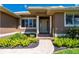 This home showcases a brick walkway to the front door flanked by columns, manicured shrubs, and healthy green grass at 695 Macedonia Dr, Punta Gorda, FL 33950