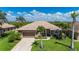 Beautiful single-story home with a well-manicured lawn, mature palm trees, and a two-car garage at 695 Macedonia Dr, Punta Gorda, FL 33950