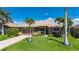 Lovely single-story home with lush greenery, swaying palm trees, and a brick-paved driveway at 695 Macedonia Dr, Punta Gorda, FL 33950