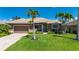 Inviting single-story home with well-maintained lawn, palm trees, and a two-car garage at 695 Macedonia Dr, Punta Gorda, FL 33950