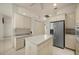 Bright kitchen features a center island, tile floors, stainless refrigerator and white cabinetry at 695 Macedonia Dr, Punta Gorda, FL 33950