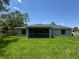 A spacious backyard features vibrant green grass and the home's screened-in lanai at 7381 De Brita Rd, North Port, FL 34291