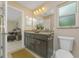 Well-lit bathroom featuring double sink vanity with granite countertops, dark cabinets, and tiled floors at 7381 De Brita Rd, North Port, FL 34291