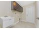 Bright laundry room features overhead cabinets, utility sink, tile flooring and indoor access to the outside at 7381 De Brita Rd, North Port, FL 34291
