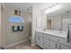 Well-lit bathroom featuring a double sink vanity, wall mirror, half-moon window and tiled floors at 7448 S Blue Sage, Punta Gorda, FL 33955