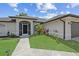 Inviting front entrance with screened porch, arched windows, and a well-manicured lawn at 7448 S Blue Sage, Punta Gorda, FL 33955