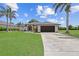Lovely single-story home with a well-maintained lawn, a dark garage door and tropical palm trees at 7448 S Blue Sage, Punta Gorda, FL 33955